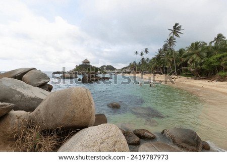 Famous colombian tayrona national beach knowed as Cabo San Juan with tourist into caribbean sea and roustic hut viewpoint at the top of a mountain