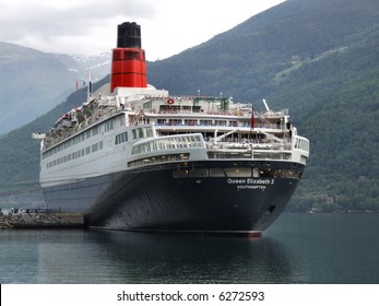 Famous Cruise Ship - Queen Elizabeth II From Southampton In A Small Harbor In A Norwegian Fjord.