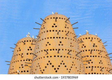 Famous Earthen Pigeon Towers With White Pigeon Flying Away In Katara Cultural Village Of Doha, Qatar