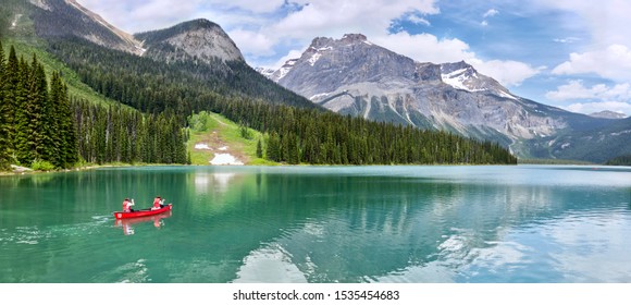 Famous Emerald Lake, Yoho National Park, British Columbia, Canada. Turquoise water and green trees. Red canoe on the lake.