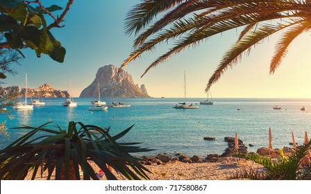 Famous, empty and beautiful Cala d'Hort beach, in summer very popular, sandy coast have a fantastic view of mysterious island of Es Vedra. Moored vessels on bay. Ibiza Island, Balearic Islands. Spain - Powered by Shutterstock
