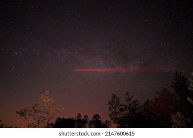 The famous Estonian swamp Viru Raba, a night scene with a milky way and a red laser beam aimed at the sky. - Powered by Shutterstock