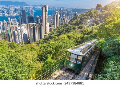 The famous green tram on the slope of Victoria Peak in Hong Kong passes, lifting visitors to the observation deck at the top.