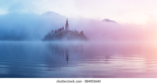 Famous island with old church in the city of Bled. Misty morning with gorgeous lights and colors. Alps mountains in the background. Slovenia, Europe - Powered by Shutterstock