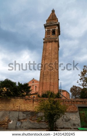 Famous leaning bell tower Campanile Pendente of Saint Martin Bishop Church on Burano island, Venice, Italy.