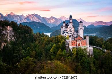The famous Neuschwanstein castle during sunrise, with colorful panorama of Alps in the background