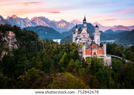 The famous Neuschwanstein castle during sunrise, with colorful panorama of Alps in the background