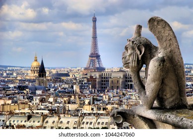 Famous Notre Dame gargoyle overlooking the Paris cityscape with Eiffel Tower