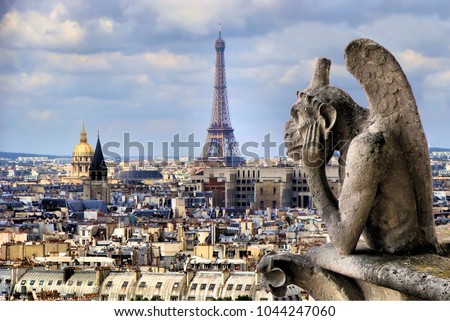 Famous Notre Dame gargoyle overlooking the Paris cityscape with Eiffel Tower 