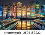 Famous old houses of Amsterdam. The houses stand in the water and have a beautiful reflection. Touristic district Damrak. These houses are famous all over the world. Amsterdam, Holland, Europe