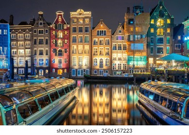 Famous old houses of Amsterdam. The houses stand in the water and have a beautiful reflection. Touristic district Damrak. These houses are famous all over the world. Amsterdam, Holland, Europe