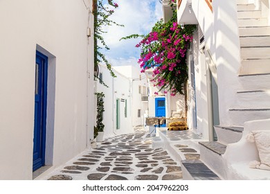 Famous old town narrow street with white houses and Bougainvillea flower. Mykonos island, Greece. - Powered by Shutterstock