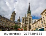 The famous Rouen Cathedral (Cathedral Notre Dame de Rouen)   -  amazing architecture of medievak France .People in distance sirrinf in cafe and walking 