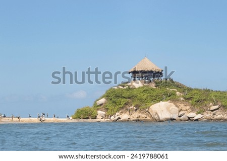 Famous roustic viewpoint hit at the top of a mountain into Cabo San Juan beach at colombian tayrona national park in sunny day
