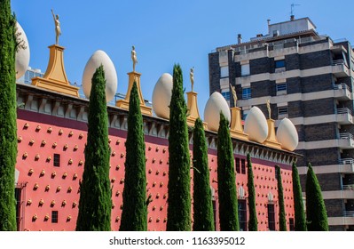 The Famous Salvador Dalí Theatre And Museum In Figueres, Catalonia, Spain, Europe. The Façade Is Topped By A Series Of Giant Eggs And Golden Figures.