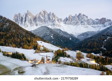 Famous Santa Magdalena mountain village with Church Chiesa di Santa Maddalena in the autumn Dolomites. Snowy Gruppo delle Odle mountain range in the background. Val di Funes, South Tyrol, Italy