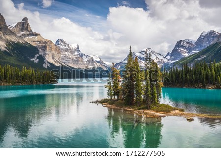 The famous Spirit Island of Maligne Lake in Jasper National Park of Alberta, Canada. Vivid blue-green waters of the glacially fed lake shine in the sunshine around the famous gathering of pines.