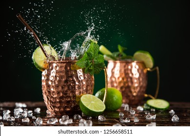 Famous splashing Moscow mule alcoholic cocktail in copper mugs, freeze motion effect. - Powered by Shutterstock