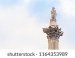 Famous statue of Admiral Nelson on Trafalgar Square in London, UK, on blue clear sky.