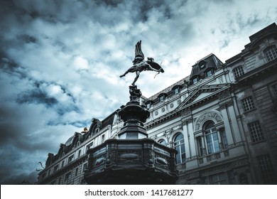 Famous statue of Eros, Amor, Cupid at Piccadilly Circus in London, UK, on blue clear sky and dramatic background 