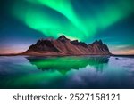 Famous Stokksnes mountains on Vestrahorn cape in Iceland under incredible sky with Northern lights. Aurora borealis. Polar lights. Landscape photography