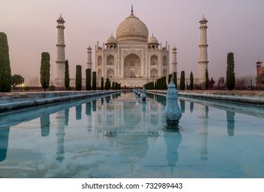 The famous Taj Mahal, Agra, India, is reflected in the water of the gardens' pools at dusk