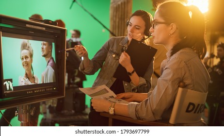 Famous Talented Female Director In Chair Looks At Display Talks With Assistant, Shooting Blockbuster. Green Screen Scene In Historical Drama. Film Studio Set Professional Crew Doing High Budget Movie