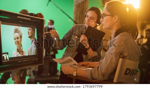 Famous Talented Female Director in Chair Looks at\
Display talks with Assistant, Shooting Blockbuster. Green Screen\
Scene in Historical Drama. Film Studio Set Professional Crew Doing\
High Budget Movie