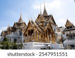 Famous Thailand temple, the Grand Palace in Bangkok, with traditional ornate Thai architecture. The palace has golden spires and decorative rooftop.