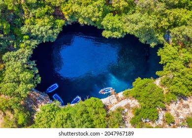 Famous tourist attraction. Aerial drone view of iconic cave with Melissani Lake near Sami village, Kefalonia island, Greece.