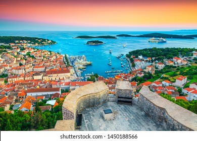 Famous touristic and travel destination. View from the Tvrdava Fortica (Spanjola) fortress at sunset. Green islands, blue lagoons and fantastic harbor, Hvar, Hvar island, Dalmatia, Croatia, Europe