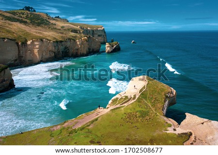 Famous Tunnel beach in New Zealand, DUNEDIN, NEW ZEALAND Popular tourist attraction in Dunedin, South island of New Zealand, amazing coast line from above with a drone, Cliff formations Tunnel Beach