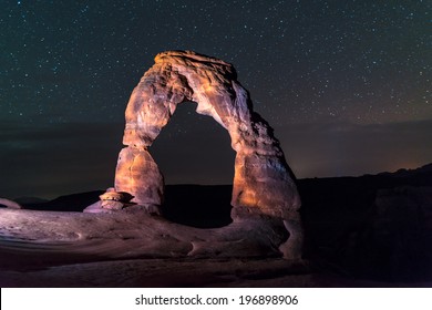 Famous Utah Landmark Delicate arch photographed at night with clean skies and shooting stars - Powered by Shutterstock