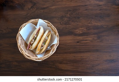 Famous Vietnamese bread (Banh Mi) for breakfast in Dalat, Vietnam. Homemade savoury Vietnamese sandwich, bread stuffed on bamboo plate with wooden table background, Popular street food from Vietnam. 