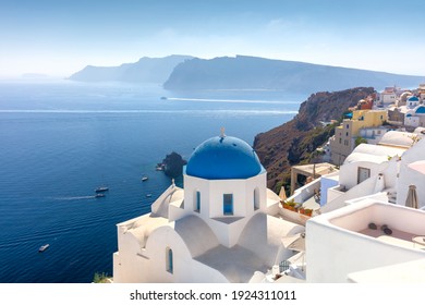 Famous view of Oia town cityscape at Santorini island in Greece. Traditional blue dome and white houses. Greece, Aegean sea. Famous European destination