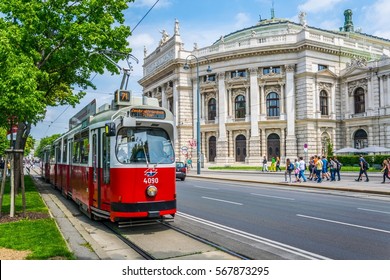 Famous Wiener Ringstrasse with historic Burgtheater (Imperial Court Theatre) and traditional red electric tram