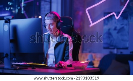 Famouse Female Gamer Playing Online Video Game on Computer. Portrait of Happy Relaxed Woman in Headphones Battling in PvP Tournament with Other Players, Talking with Team on Microphone.
