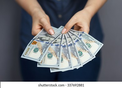 Fan of 100 dollar banknotes in beautiful woman hands