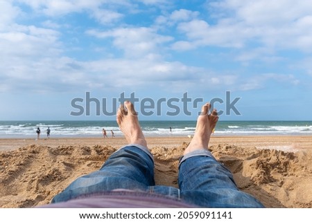 Fan feet on the sand facing the sea in Normandy