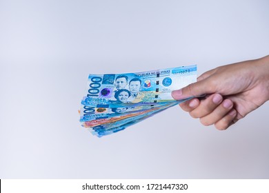 Fan of  Philippines peso  banknotes in female hand. Woman's hands show Philippine pesos money. Girls hands holding money of Philippines. Asian currency. Close up on a fan of Philippines peso notes