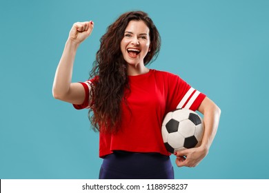 Fan sport woman player holding soccer ball isolated on blue studio background. Human facial emotions concept. Trendy colors