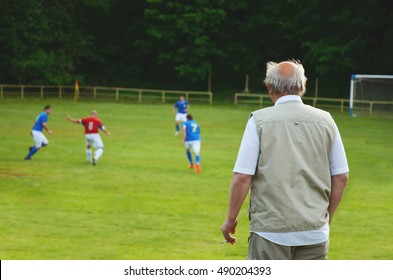 Fan Standing And Looking At Local Football Match