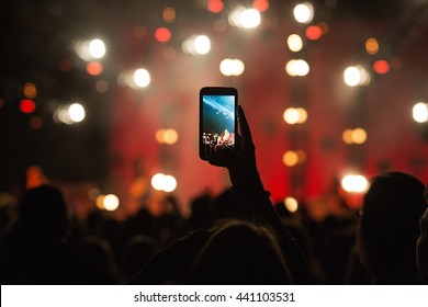 Fan Taking Photo With Cell Phone At A Concert