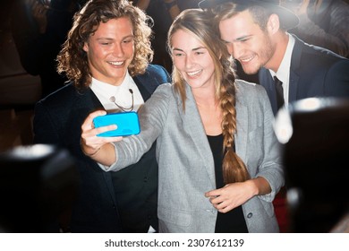 Fan taking selfie with celebrities at event - Shutterstock ID 2307612139