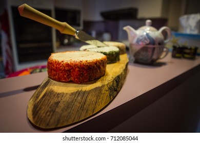 Fancy Cheese Platter Of Three Cheeses On A Tasmanian Hardwood Platter. In The Background, An Experience Tea Cup Sits.