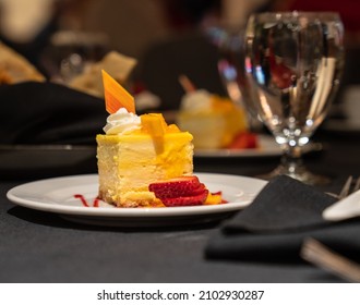 A Fancy Dessert With A Sliced Strawberry On A Plate Near A Glass On The Table