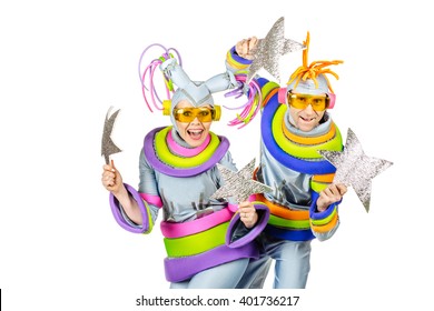 Fancy Dress Party. Two Joyful Clown With  Futuristic Yellow Glasses And Creative Metallic Silver Costumes.image Isolated Over White Background