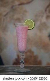 Fancy Frozen Strawberry Drink With Lime Slice And Decorative Background
