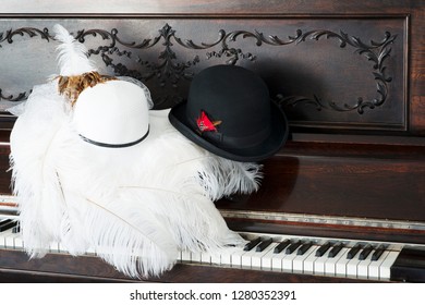 Fancy Hats On An Old 1890 Piano With Keys Showing. White Womens Derby Hat And A Black Mens Bowler Derby Hat. 