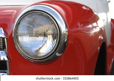 Fancy headlight of a vintage red car